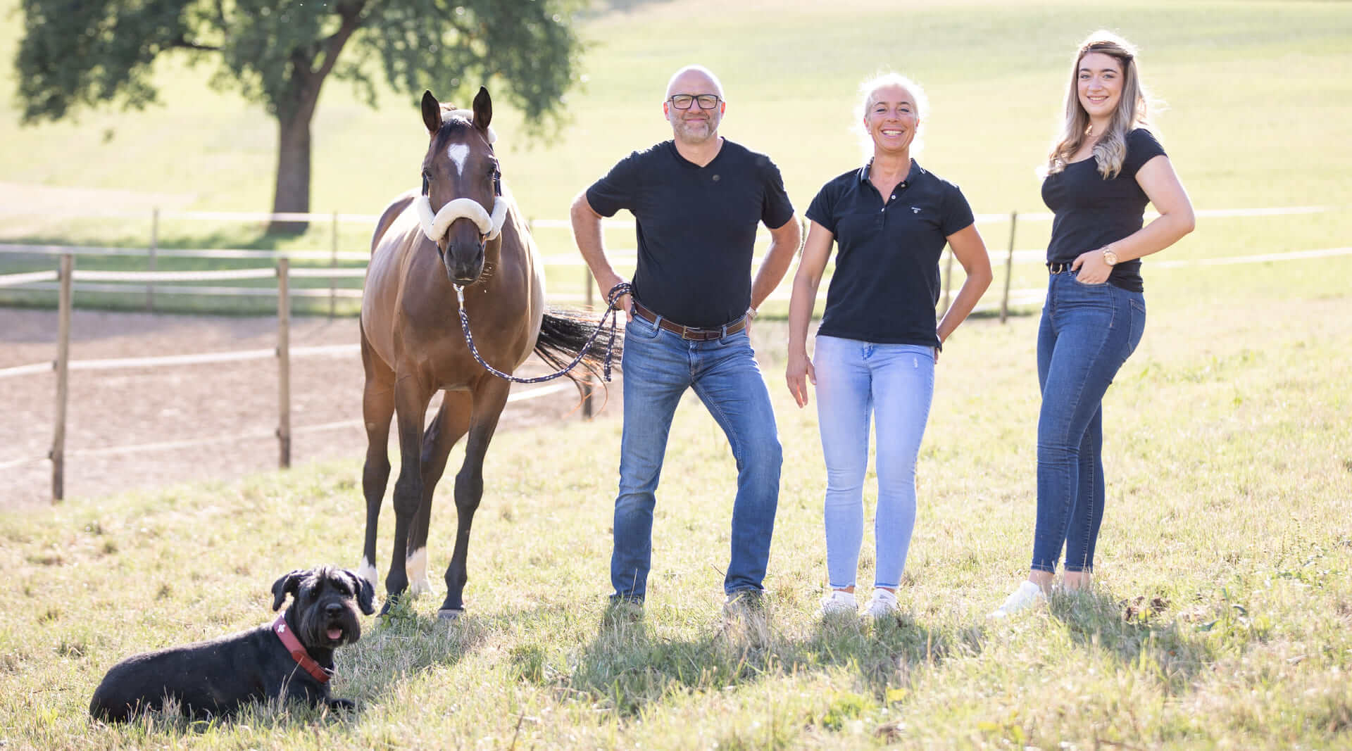 HBD Vital - Familie Beifuss Familie Beifuss steht mit Hund Luise und Pferd auf einer Weide bei strahlendem Sonnenschein